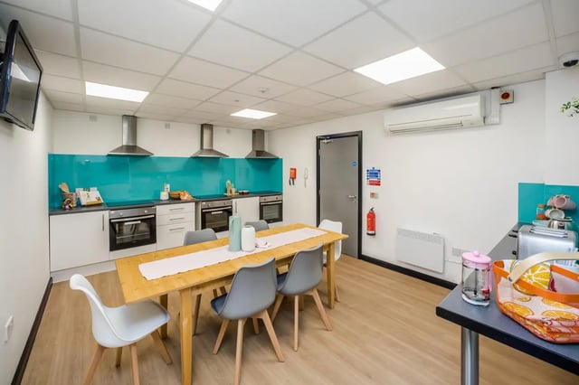 Dining table chairs ovens turquoise backsplash kitchen area at Crosstrend House in Lincoln Student Accommodation