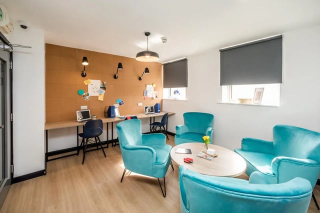 Study desks and teal chairs with coffee table living room at Crosstrend House in Lincoln Student Accommodation