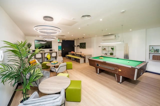 Pool table seating area television and plant common area at Crosstrend House in Lincoln Student Accommodation