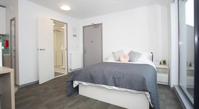 Bed with grey duvet pillows and bedside table bedroom at Duresme Court in Durham Student Accommodation