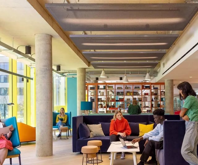 Students relaxing on sofas with laptops living room at Scape Guildford in Guildford Student Accommodation