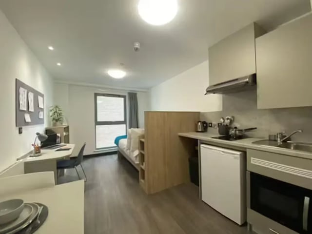 Bed desk kitchen area and small bed studio apartment at Swanston House in Belfast Student Accommodation