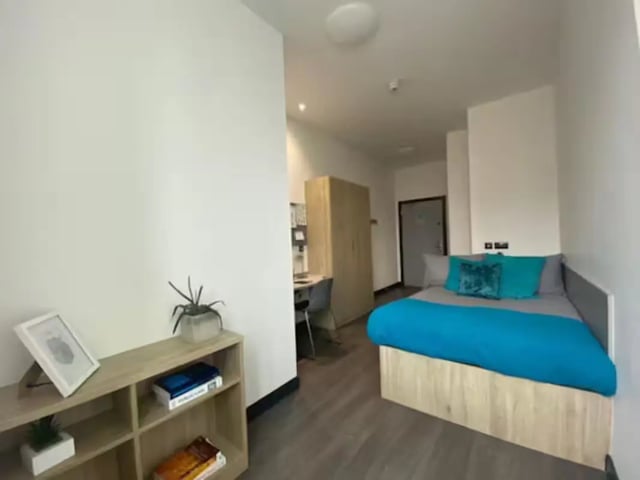 Bed wardrobe desk and bookshelf student bedroom at Swanston House in Belfast Student Accommodation