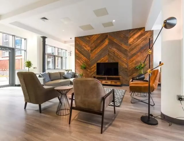 Sofa TV chairs wood accent wall living room at Swanston House in Belfast Student Accommodation
