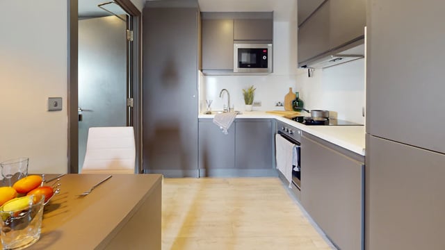 Modern gray kitchen with microwave and stove kitchen at 33 Parkside in Coventry Student Accommodation