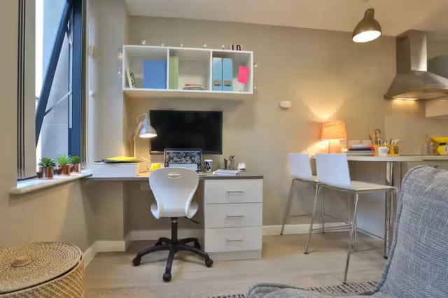 Desk television shelving bar stools kitchen area interior at James House in Bath Student Accommodation