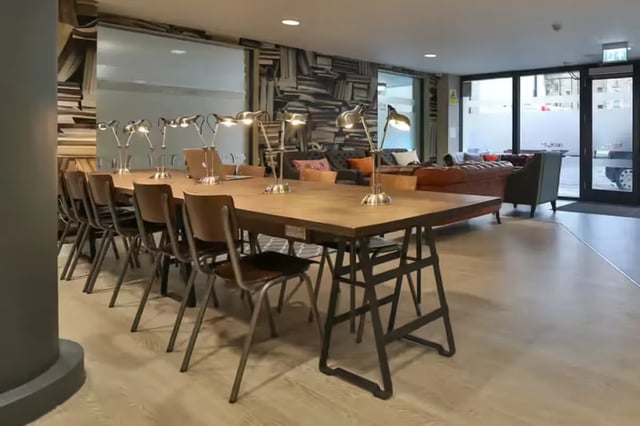 Long table with chairs lamps and sofas communal area at James House in Bath Student Accommodation