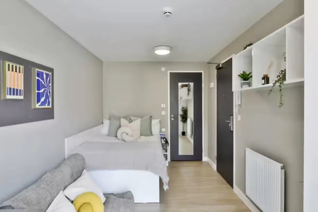 Bed sofa paintings and shelf bedroom at James House in Bath Student Accommodation