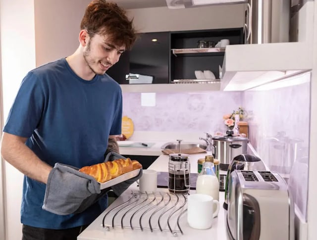 Student bakes bread in modern kitchen kitchen at Reynard House in Leicester Student Accommodation