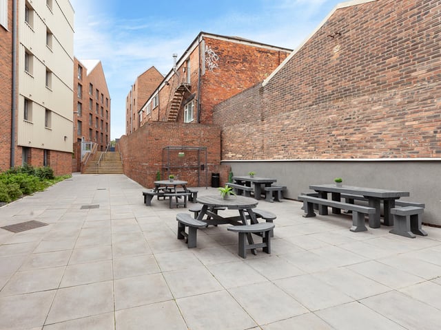 Picnic tables on paved courtyard exterior at The Glassworks Newcastle in Newcastle Upon Tyne Student Accommodation