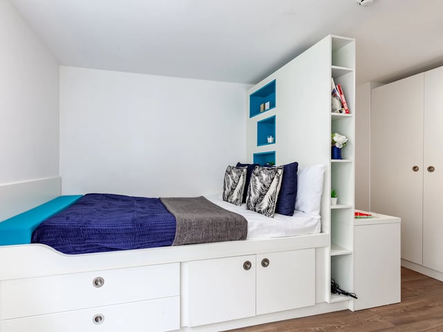 Bed with storage blue blanket patterned pillows study area bedroom at The Glassworks Newcastle in Newcastle Upon Tyne Student Accommodation