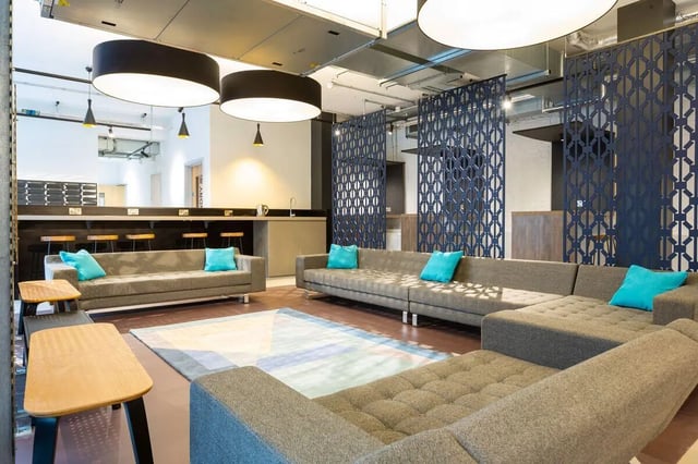 Gray sectional sofas with blue cushions communal area at Market Quarter Studios in Bristol Student Accommodation
