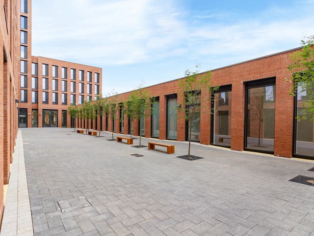 Brick buildings courtyard with benches and trees Exterior at Straits Village in Nottingham Student Accommodation