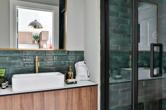 Rectangular sink golden faucet toiletries green tiles bathroom at South Bridge in Edinburgh Student Accommodation