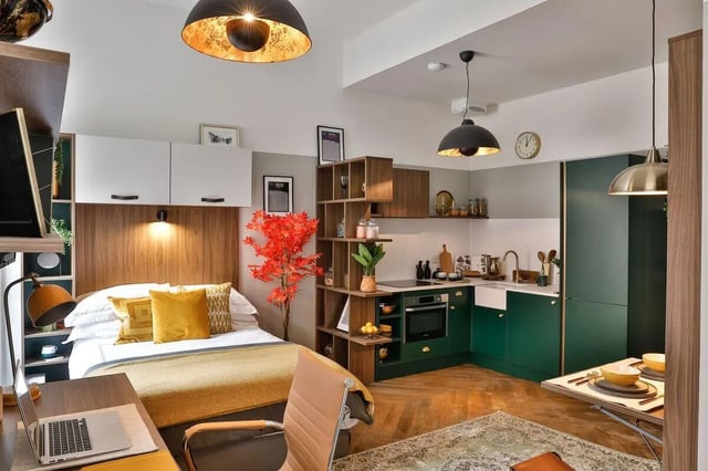 Bed desk kitchen area with green cabinets studio apartment at South Bridge in Edinburgh Student Accommodation