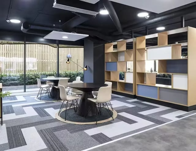 Tables chairs shelving modern common area at Pittodrie Street in Aberdeen Student Accommodation