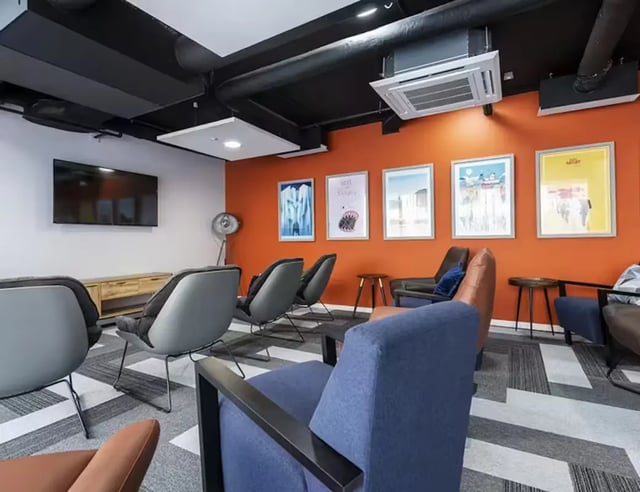 Chairs TV artwork and AC unit living room at Pittodrie Street in Aberdeen Student Accommodation
