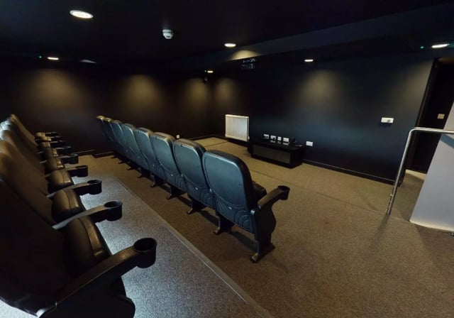 Cinema room with rows of black seats Image Type Cinema Room at iQ Collingwood in Newcastle Upon Tyne Student Accommodation