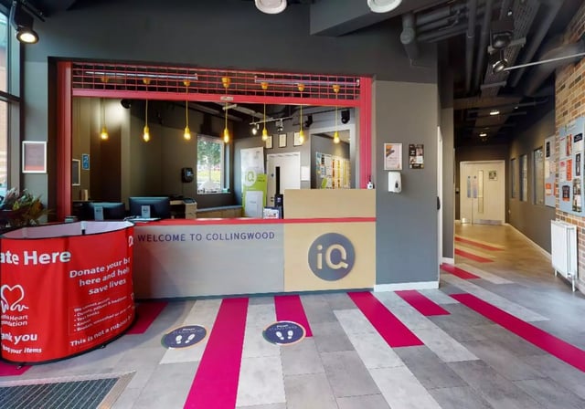 Reception desk with computers and donation bin reception area at iQ Collingwood in Newcastle Upon Tyne Student Accommodation
