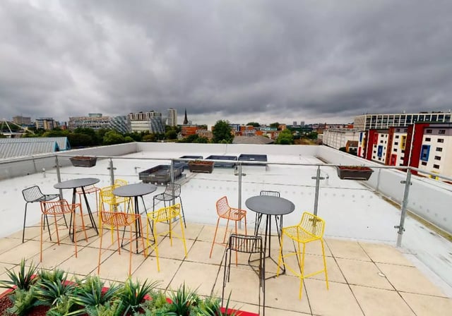 Tables and chairs on a rooftop terrace exterior at iQ Collingwood in Newcastle Upon Tyne Student Accommodation