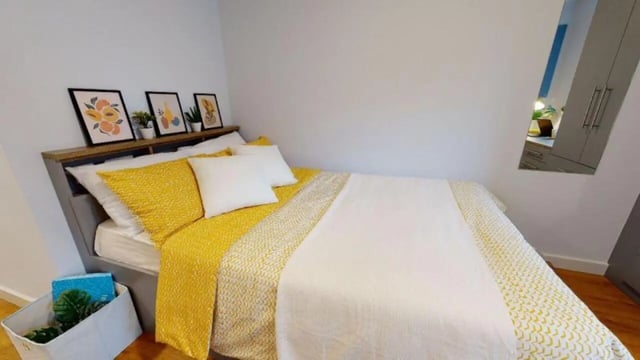 Yellow bedding artwork above bed bedside storage bedroom at iQ Collingwood in Newcastle Upon Tyne Student Accommodation