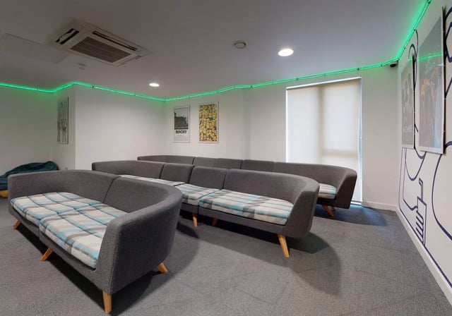 Curved grey sofas plaid cushions posters living room at iQ Century Square in Sheffield Student Accommodation