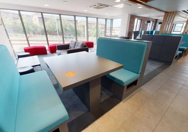 Study area with blue booths and tables common room at iQ Century Square in Sheffield Student Accommodation