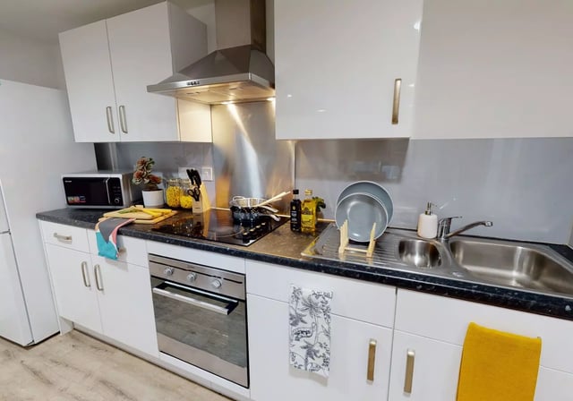 Modern kitchen with microwave oven sink and cabinets kitchen at iQ Century Square in Sheffield Student Accommodation