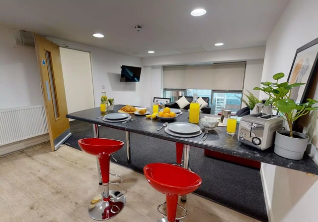 Table with breakfast red stools toaster living area kitchen at iQ Century Square in Sheffield Student Accommodation
