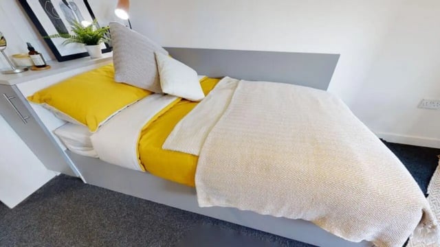 Bed with yellow duvet pillows and throw Bedroom at iQ Century Square in Sheffield Student Accommodation