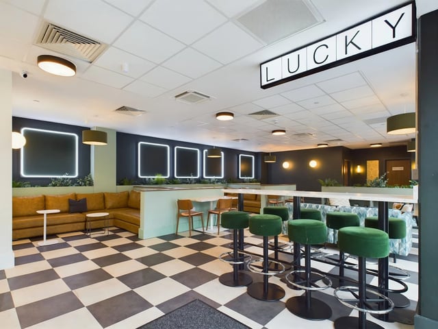 Modern common area with sectional sofa bar stools living room at Crown Place - Nottingham in Nottingham Student Accommodation