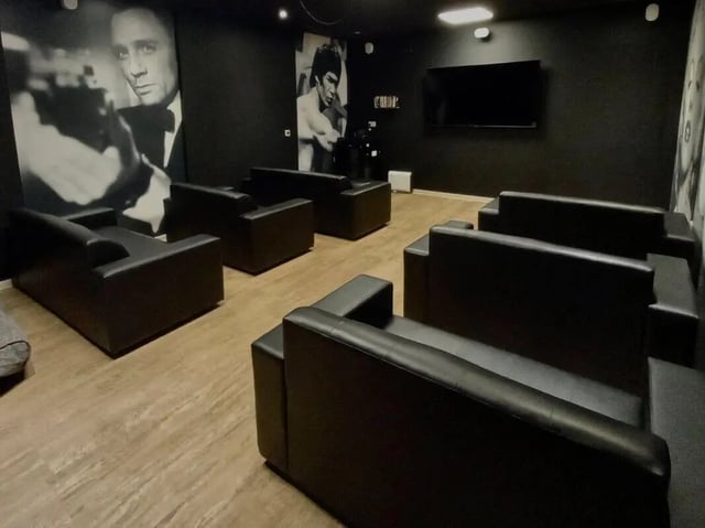 Black sofas movie posters wall mounted television living room at Picturehouse Apartments in Exeter Student Accommodation