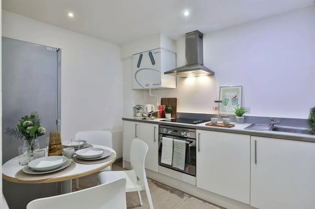 Table chairs refrigerator stove sink kitchen at Picturehouse Apartments in Exeter Student Accommodation