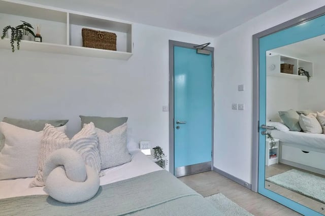 Bed with pillows and shelves above bedroom at Picturehouse Apartments in Exeter Student Accommodation