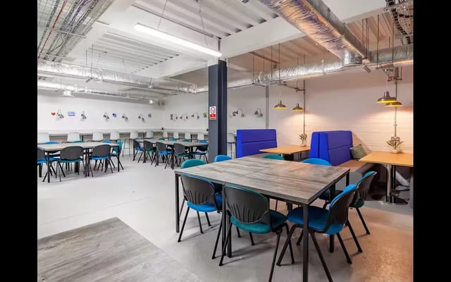 Dining tables with blue chairs communal area at Medici in Nottingham Student Accommodation