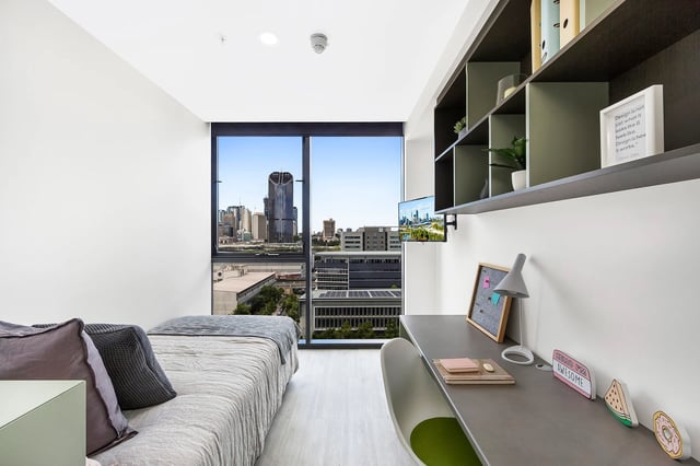 Bed desk and city view student accommodation bedroom at Scape Merivale in Brisbane Student Accommodation