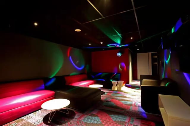 Red couches coffee tables disco lights recreation area at Scape at University of Sydney in Sydney Student Accommodation