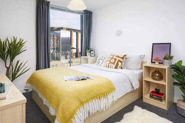 Bed with yellow blanket and pillows study area at Harriet Martineau in Birmingham Student Accommodation