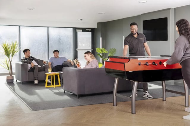 Students lounging and playing foosball living room at Harriet Martineau in Birmingham Student Accommodation
