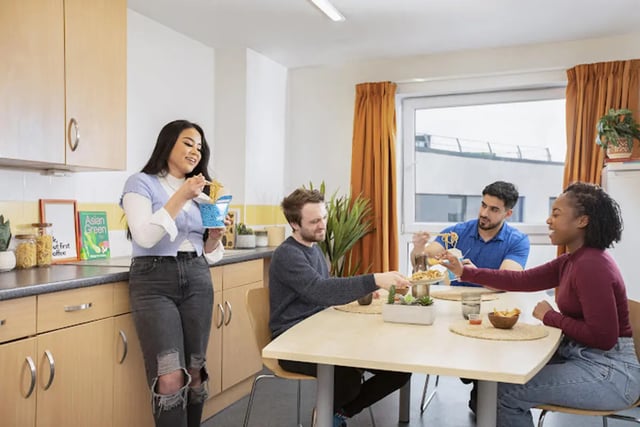 Students eating noodles at a communal kitchen table at Harriet Martineau in Birmingham Student Accommodation
