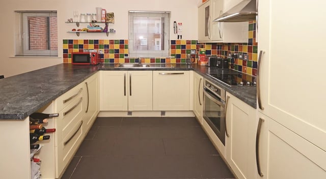 Modern U-shaped kitchen with cream cabinets wine rack kitchen at Hassells Bridge House in Newcastle Under Lyme Student Accommodation
