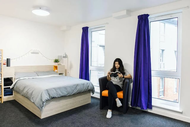 Bed with grey bedding and armchair study area bedroom at Queen's Park House in Coventry Student Accommodation