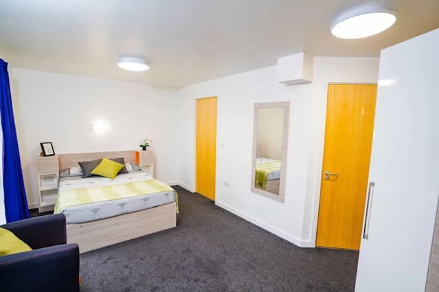 Bed, pillows, picture frame, mirror, yellow door, wardrobe bedroom at Queen's Park House in Coventry Student Accommodation