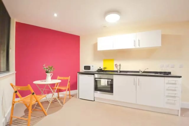 Table chairs microwave oven sink kitchen at Hydrogen in Nottingham Student Accommodation