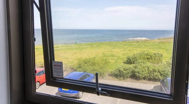 Cars and ocean view through window Exterior at East Shore in St Andrews Student Accommodation