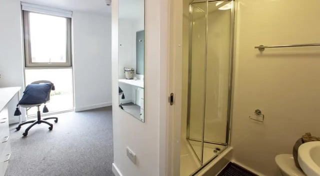 Shower and toilet with desk and chair bathroom at East Shore in St Andrews Student Accommodation