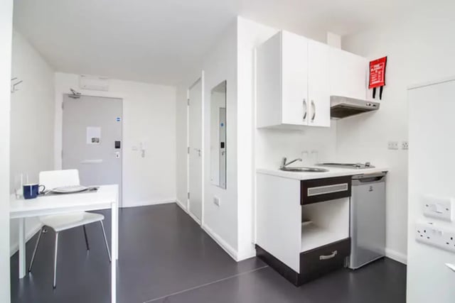 Table chair kitchen counter fridge and fire blanket kitchen at Lucas Studios in Birmingham Student Accommodation