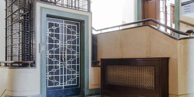 Ornate door with metal cage and radiator exterior at The Old Fire Station - Birmingham in Birmingham Student Accommodation