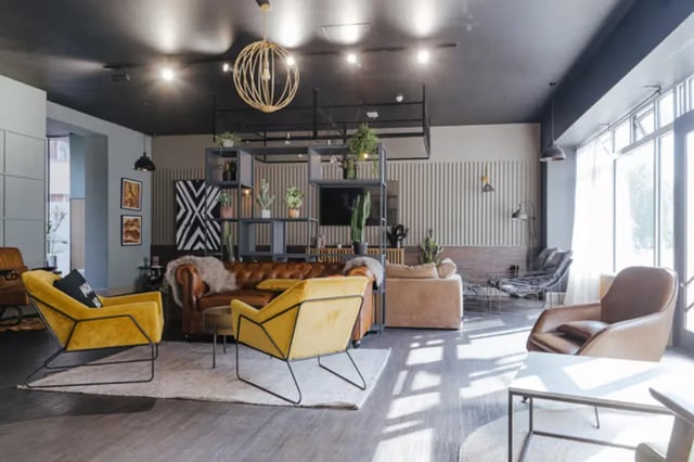 Leather sofa yellow chairs modern shelving living room at The Old Fire Station - Birmingham in Birmingham Student Accommodation