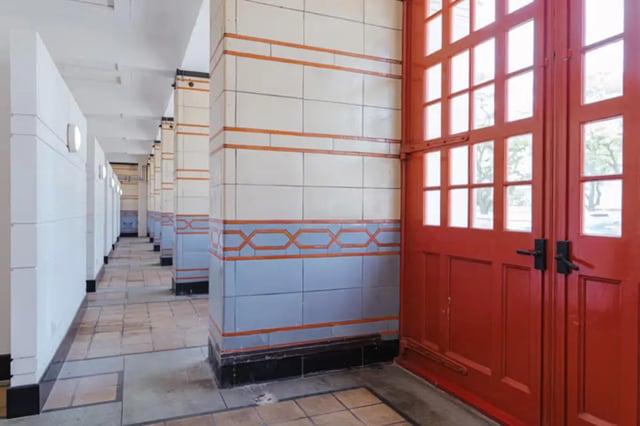 Tiled walkway with red double doors exterior at The Old Fire Station - Birmingham in Birmingham Student Accommodation